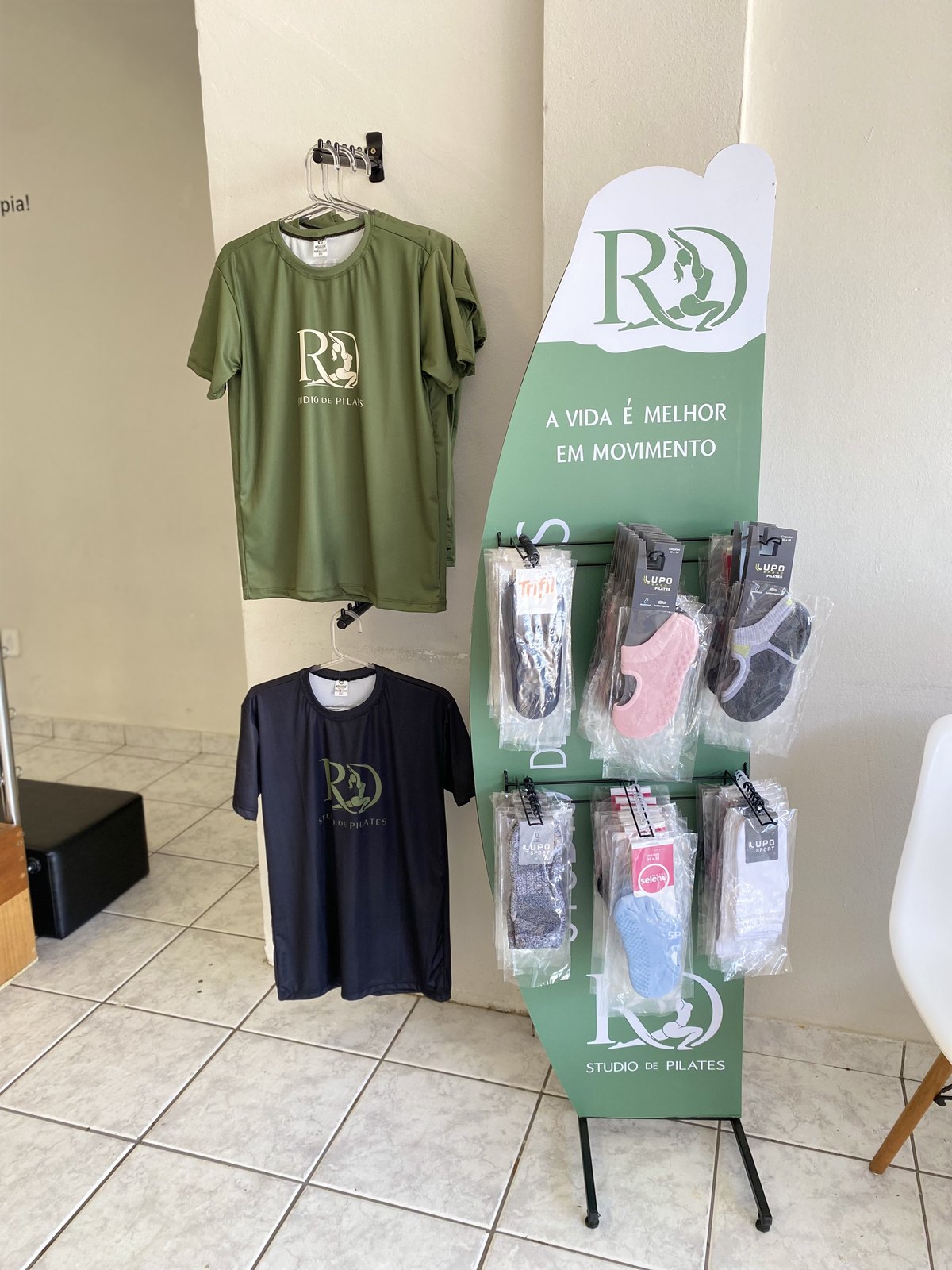 Expositor da lojinha com blusas RD Studio e meias